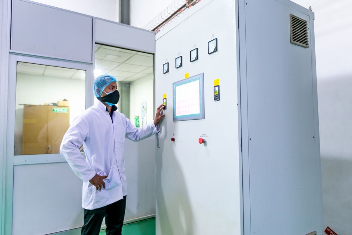A technician checking the spray-dryer control cabinet