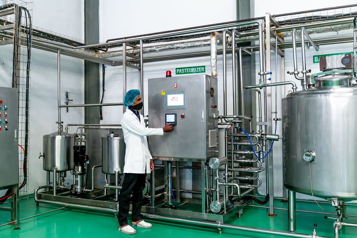 An operator at the pasteuriser control panel