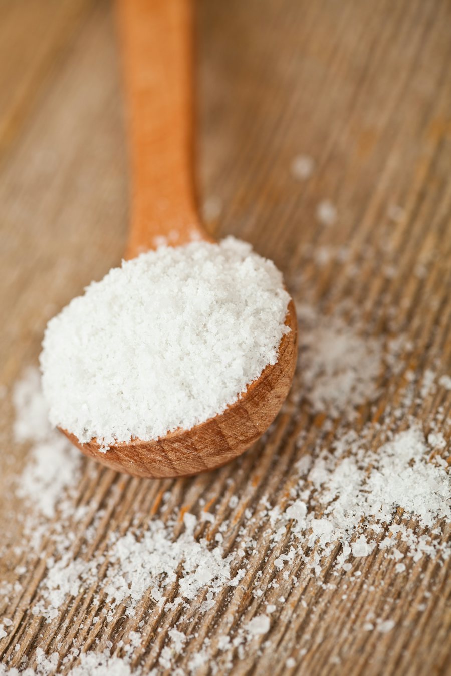 A wooden spoon heaped with coconut milk powder